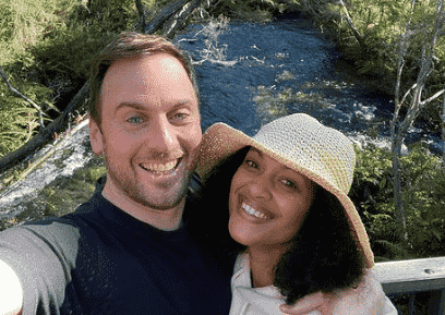 A beautiful selfie of Cynthia Addai-Robinson and her Spouse with a river and lush greenery in the background.