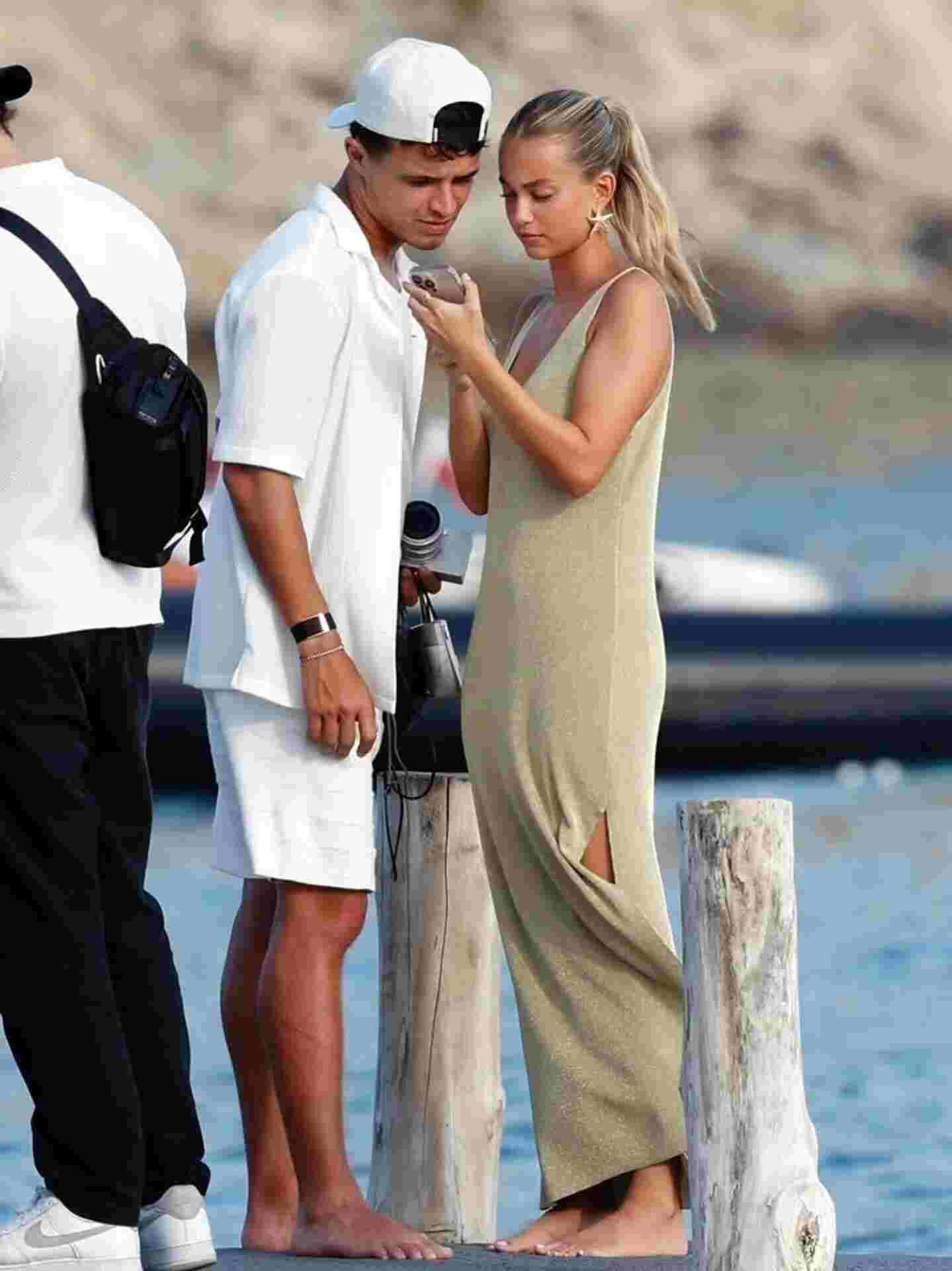 Lando Norris and his girlfriend, Margarida Corceiro, are shown standing by the water on vacation.