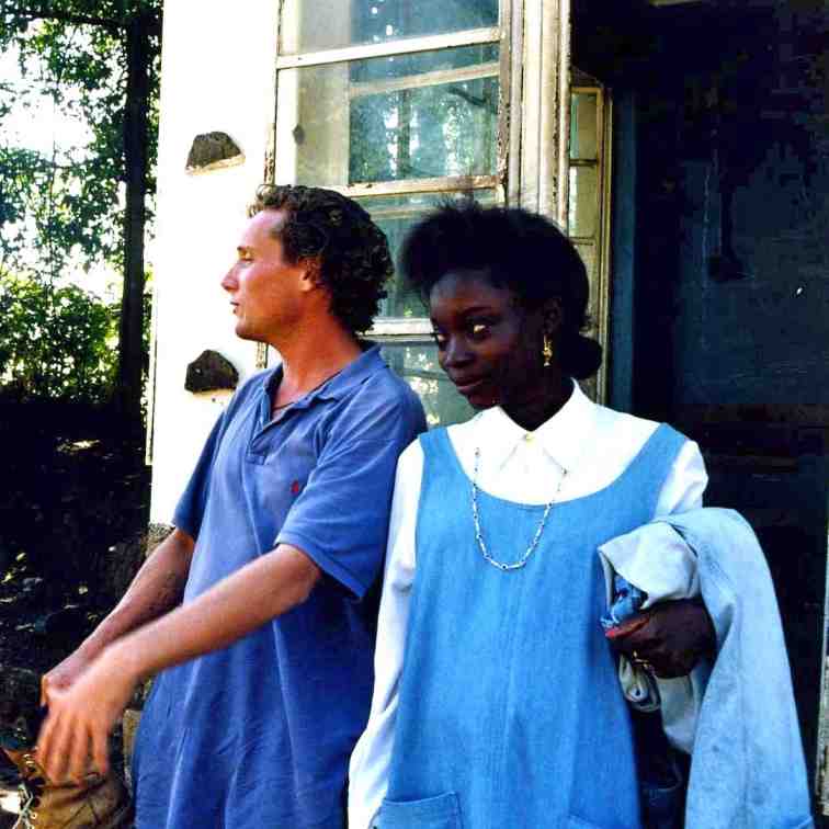 A young woman, Sophie Wilde’s mother, and a her father standing outdoors in front of a building.