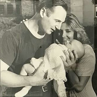 A black and white photo of Liam Neeson and Natasha Richardson with their baby.