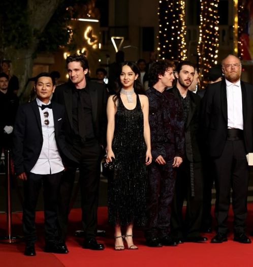 A group of actors, including Lucie Zhang, pose on the red carpet at the Cannes Film Festival.
