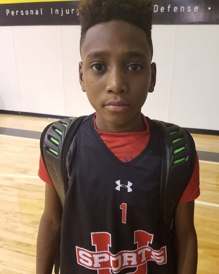 A young Tahaad Pettiford in a basketball jersey and a backpack.