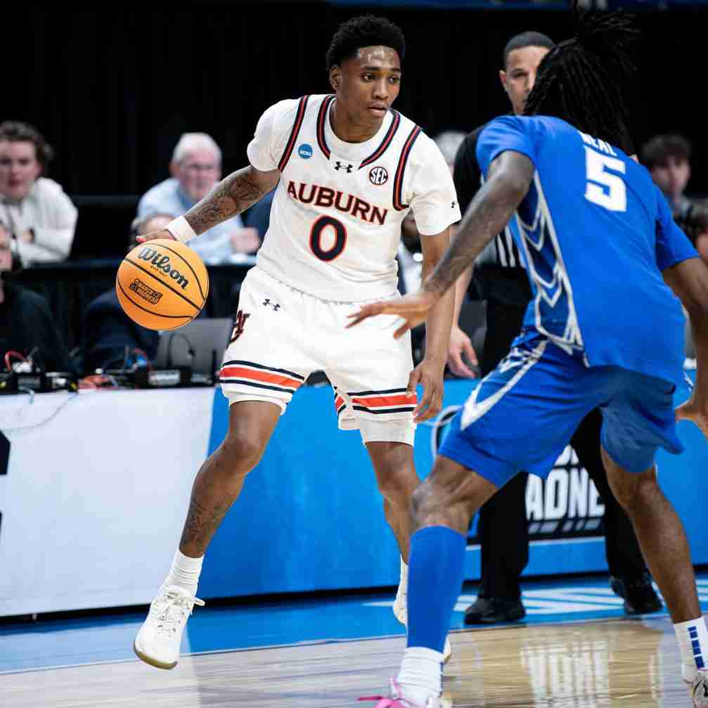 Tahaad Pettiford, in an Auburn jersey, dribbles the ball on the court.