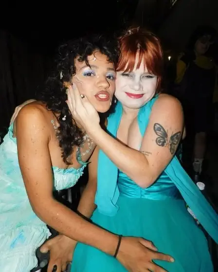 Marissa Bode has curly dark hair on left side and Lauren with red hair and a butterfly tattoo on her arm on right side.