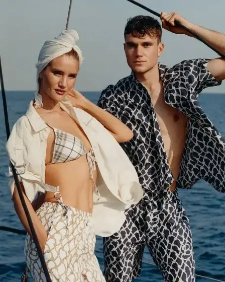Jack Draper and model Rosie Huntington-Whiteley pose on a boat against the ocean, wearing matching patterned Burberry High Summer collection resortwear.