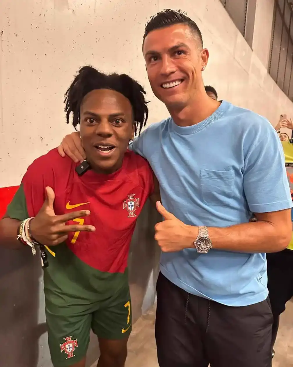 YouTuber IShowSpeed, wearing a Portugal jersey, stands next to and poses with soccer star Cristiano Ronaldo.