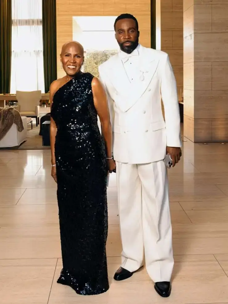 Tramell Tillman in a white suit standing next to his mother, Jae Tillman, who is wearing a black sequined gown.