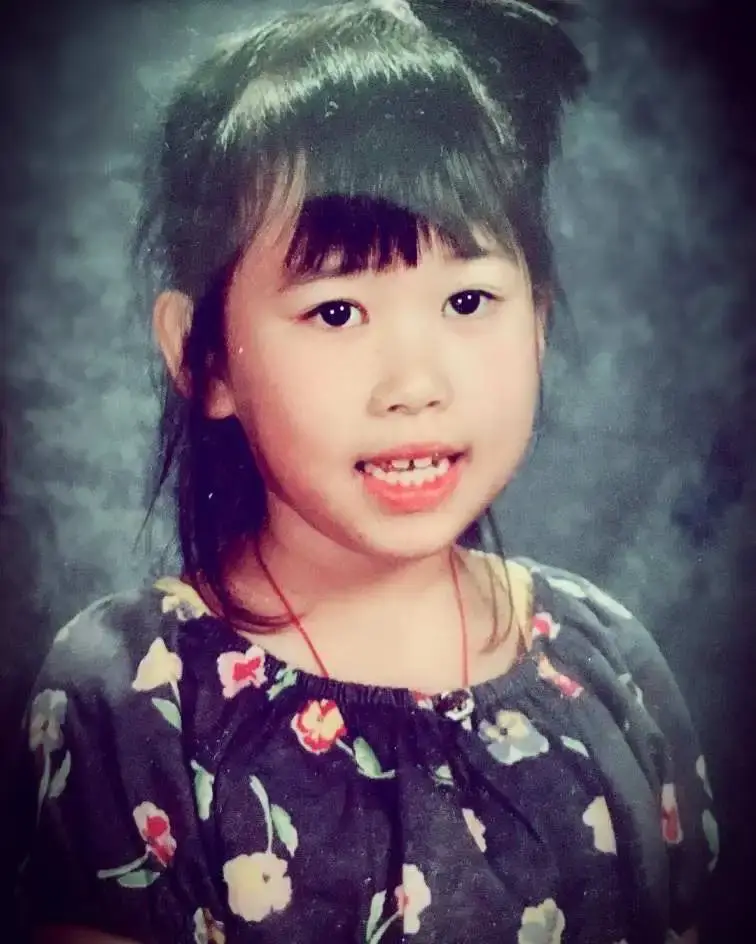 Young Ramona Young as a child, with bangs and a floral-patterned dress, smiling at the camera.