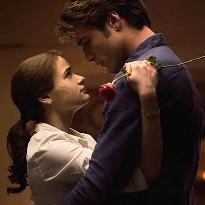 Joey King as Elle Evans and Jacob Elordi as Noah Flynn embrace while holding a single red rose in a romantic scene from The Kissing Booth.