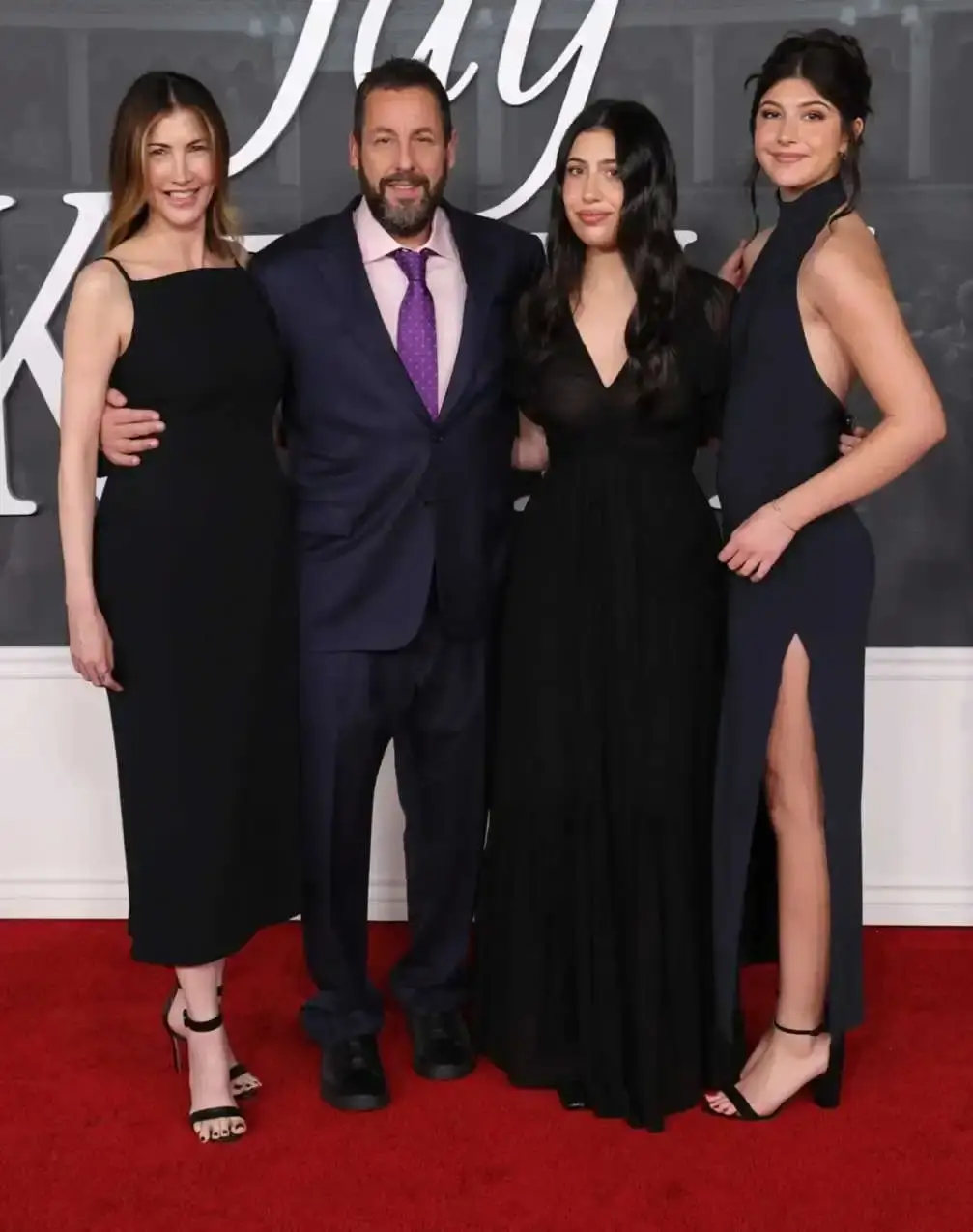 Sunny Sandler, her father Adam, her mother Jackie, and her sister Sadie pose together in coordinated black and white outfits on a prestigious film festival red carpet.