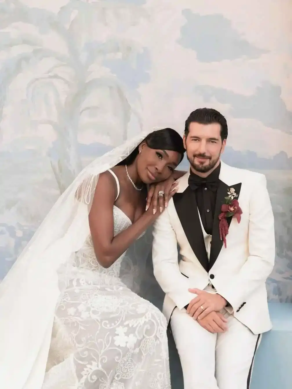 ennis legend Venus Williams and actor Andrea Preti pose together at an event, with Venus in a white dress and Andrea in a dark suit.