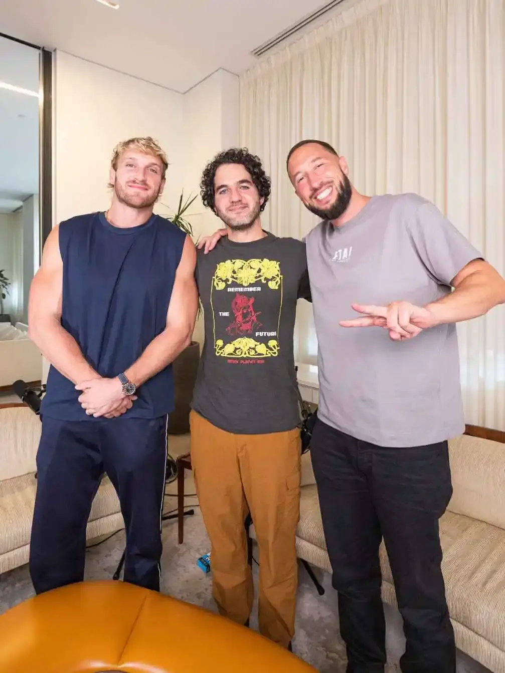 Logan Paul, Benny Safdie, and Mike Majlak stand together in a modern room smiling for a group photo.