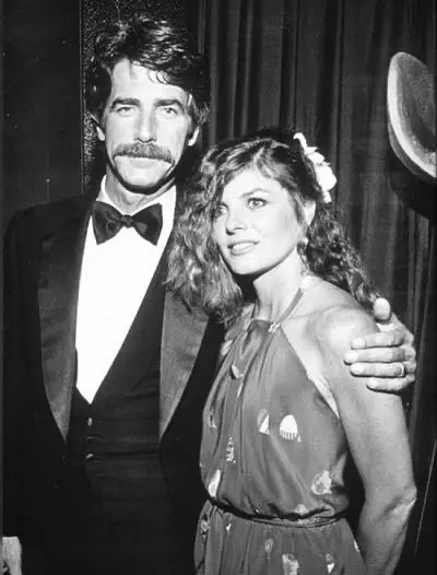 Sam Elliott and his wife Katharine Ross standing together closely while smiling at a public event.