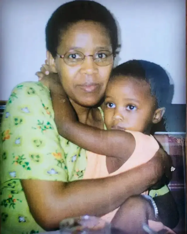 A young Masali Baduza being held closely in an affectionate embrace by her mother.