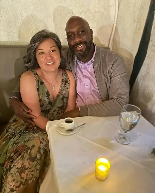 Actor Richard T. Jones and his wife, Nancy Jones, sit closely together at a candlelit restaurant table while enjoying a romantic dinner date.