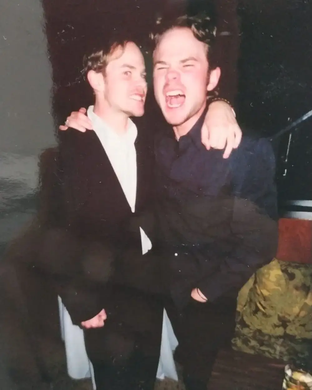 Identical twin actors Shawn and Aaron Ashmore embrace and make playful, energetic faces for a candid indoor photo.