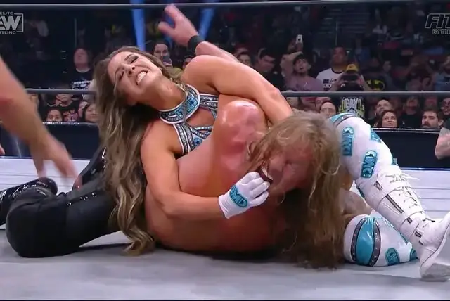 Dr. Britt Baker, D.M.D. applies her signature Lockjaw submission hold on Chris Jericho during a high-stakes mixed tag team match in the AEW ring.
