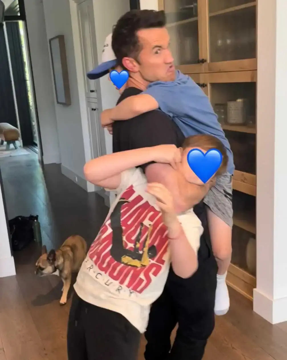 Rob McElhenney carrying and holding with his two sons, Axel and Leo, in a family portrait.