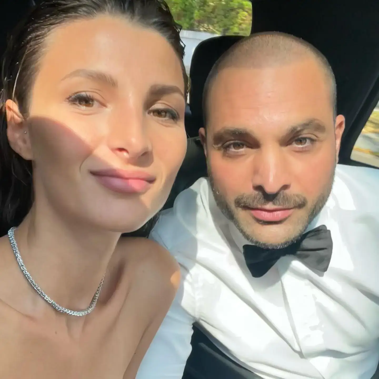 Bérénice C. Tournier and Michael Mando sit together in a car wearing formal evening attire.