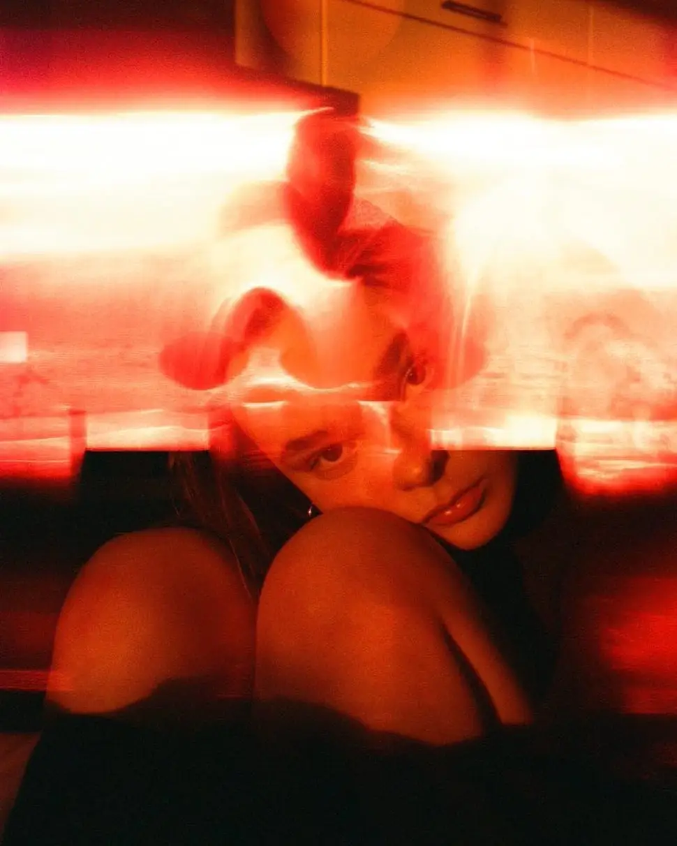 Laurel Marsden is captured in a moody, artistic portrait featuring dramatic red lighting and motion blur.