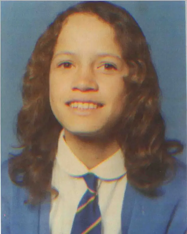 A vintage school portrait of a young Rena Owen with long curly hair, wearing a white collared shirt, a striped tie, and a blue blazer.