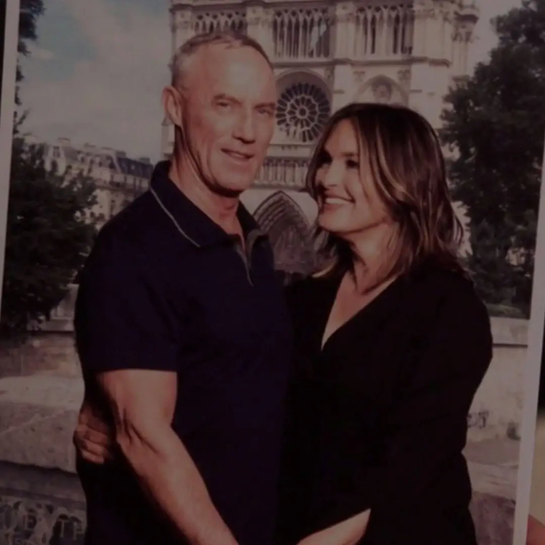 Mariska Hargitay and Robert John Burke smile warmly at each other while posing in front of the Notre Dame Cathedral in Paris.