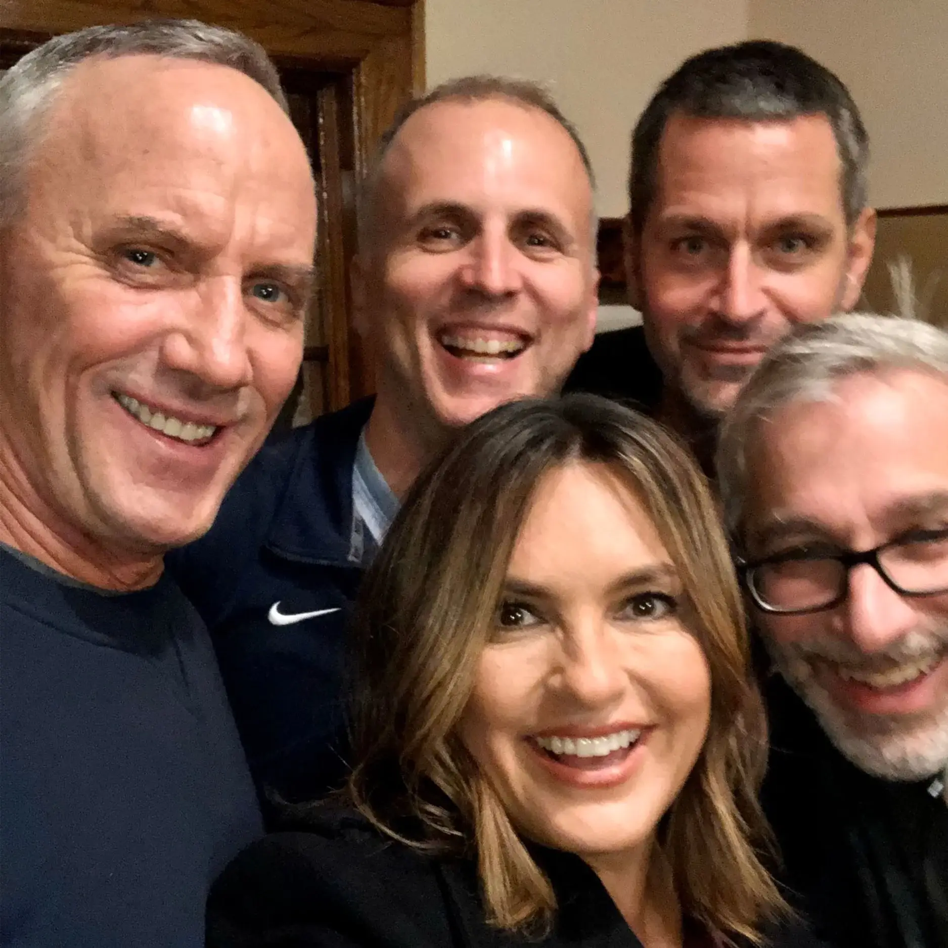 Robert John Burke, Mariska Hargitay, and colleagues smile closely together for a friendly group selfie.