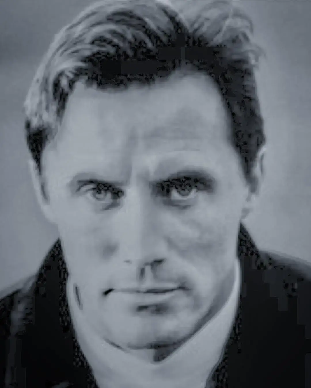 A black-and-white close-up portrait of a young Robert John Burke looking directly into the camera with a serious expression.