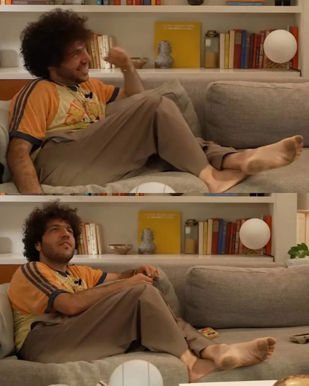Benny Blanco sits relaxed on a grey sofa with his bare feet resting on the cushions.