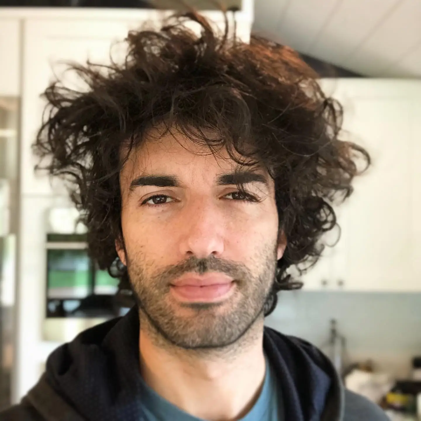 Justin Baldoni showing off his messy, voluminous curly hair.