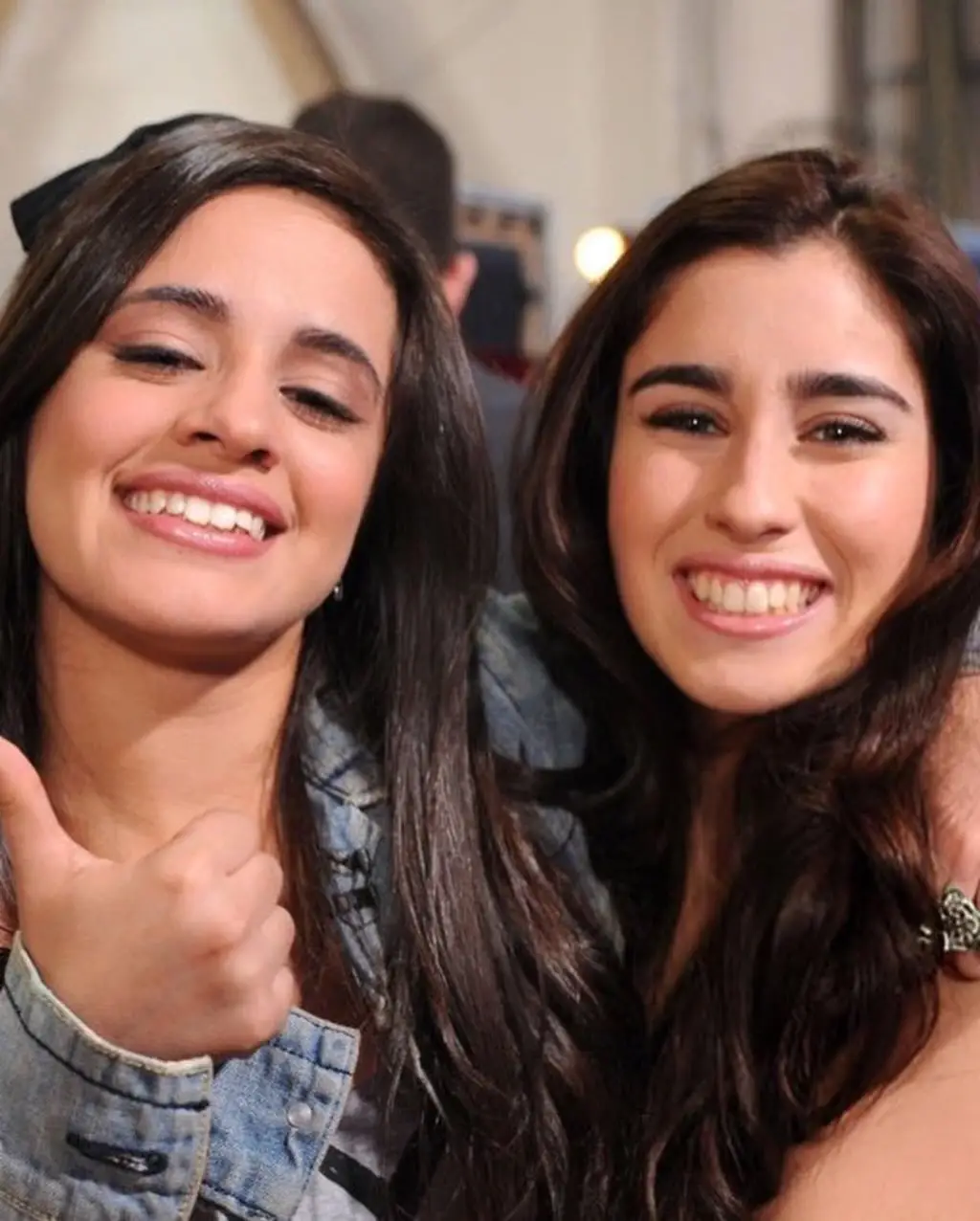Bruna Marquezine and Camila Cabello smile closely together.