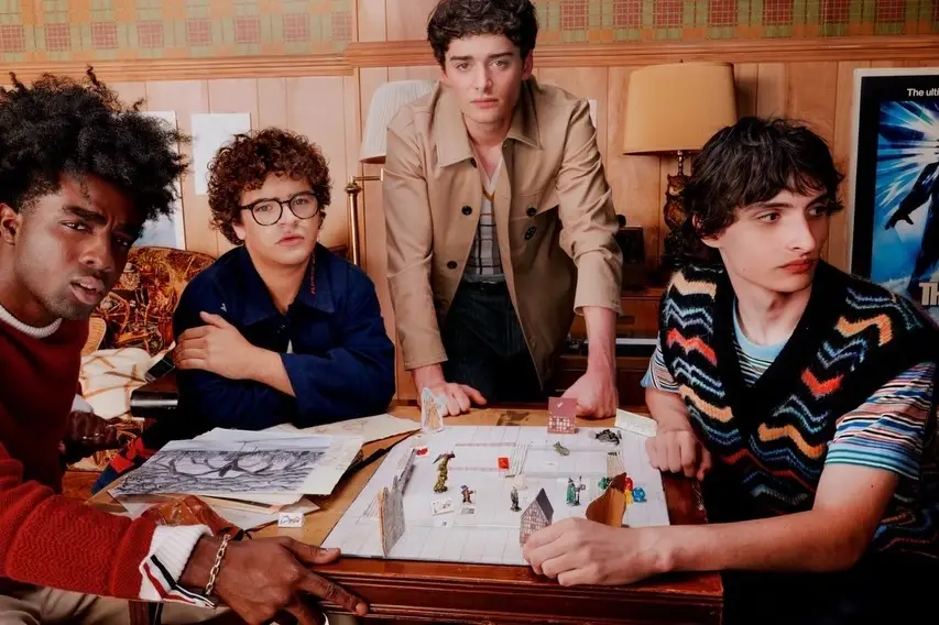 Stranger Things gathered around a Dungeons & Dragons tabletop game in a retro-themed room.