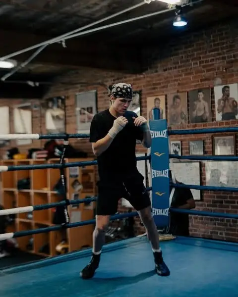 JC Kilcoyne in a boxing ring, shadowboxing in an old-school gym.