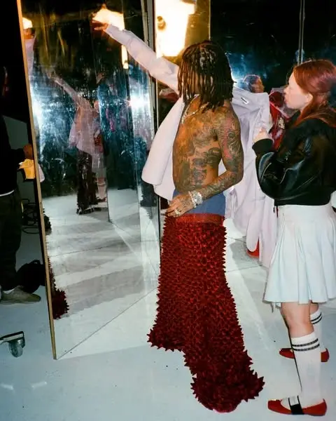 Swae Lee stands shirtless with visible tattoos.