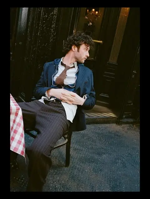 Dominic Sessa’s portrait shows him leaning back in a chair at an outdoor cafe