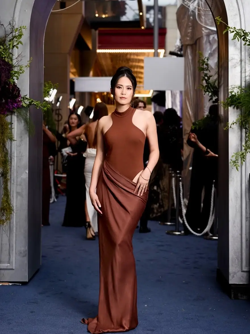 Ana Thu Nguyen wearing a sophisticated brown halter-style gown at a formal evening event.
