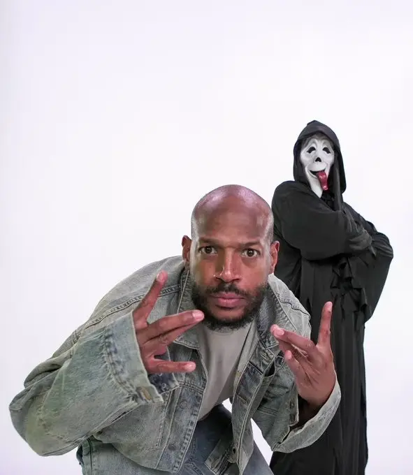 Marlon Wayans leans forward making hand gestures.