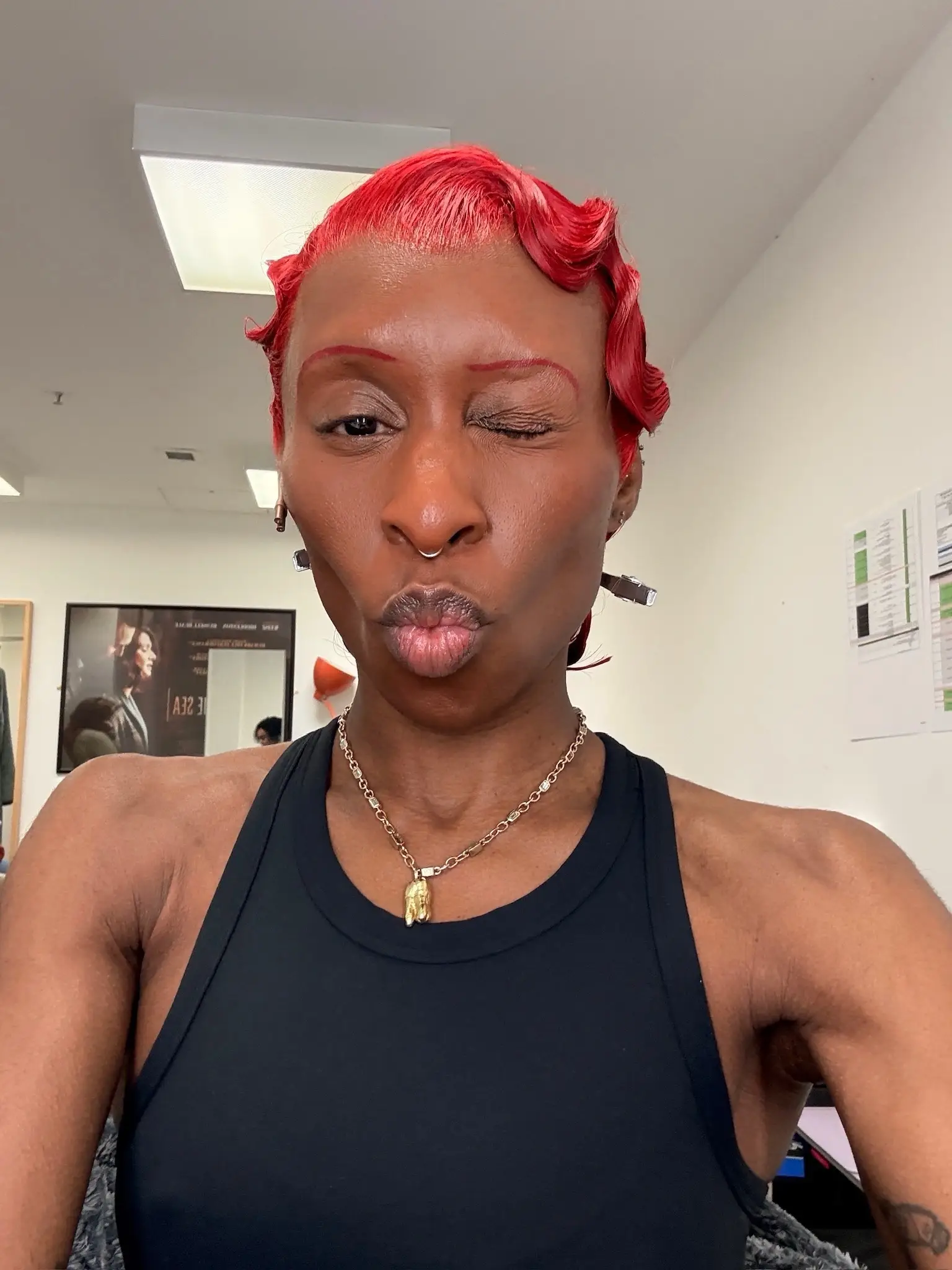 Cynthia Erivo makes a playful duck face and winks while debuting a vibrant red finger-wave hairstyle and matching red eyebrows in a selfie