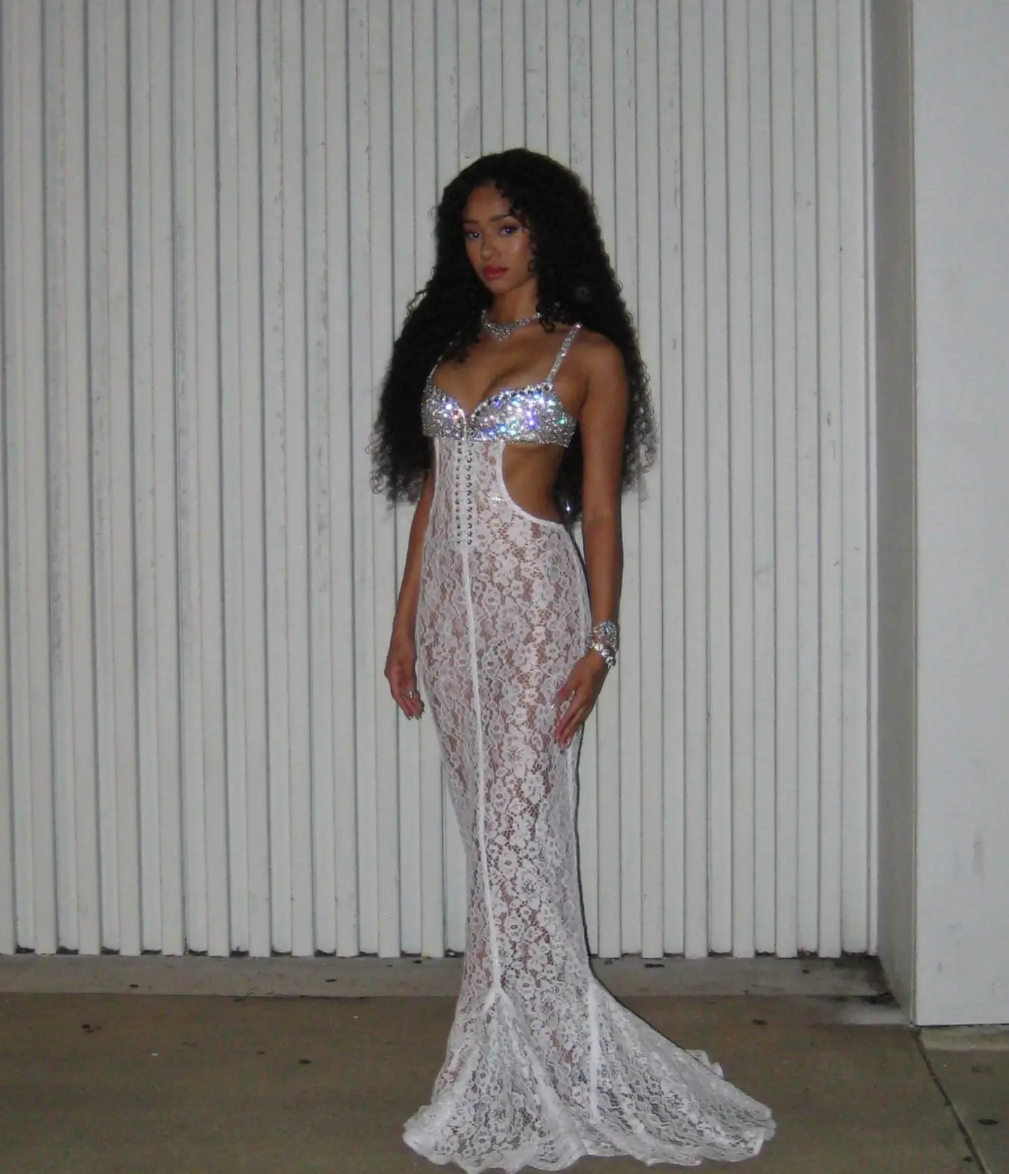 Manon Bannerman standing in a floor-length white lace gown.