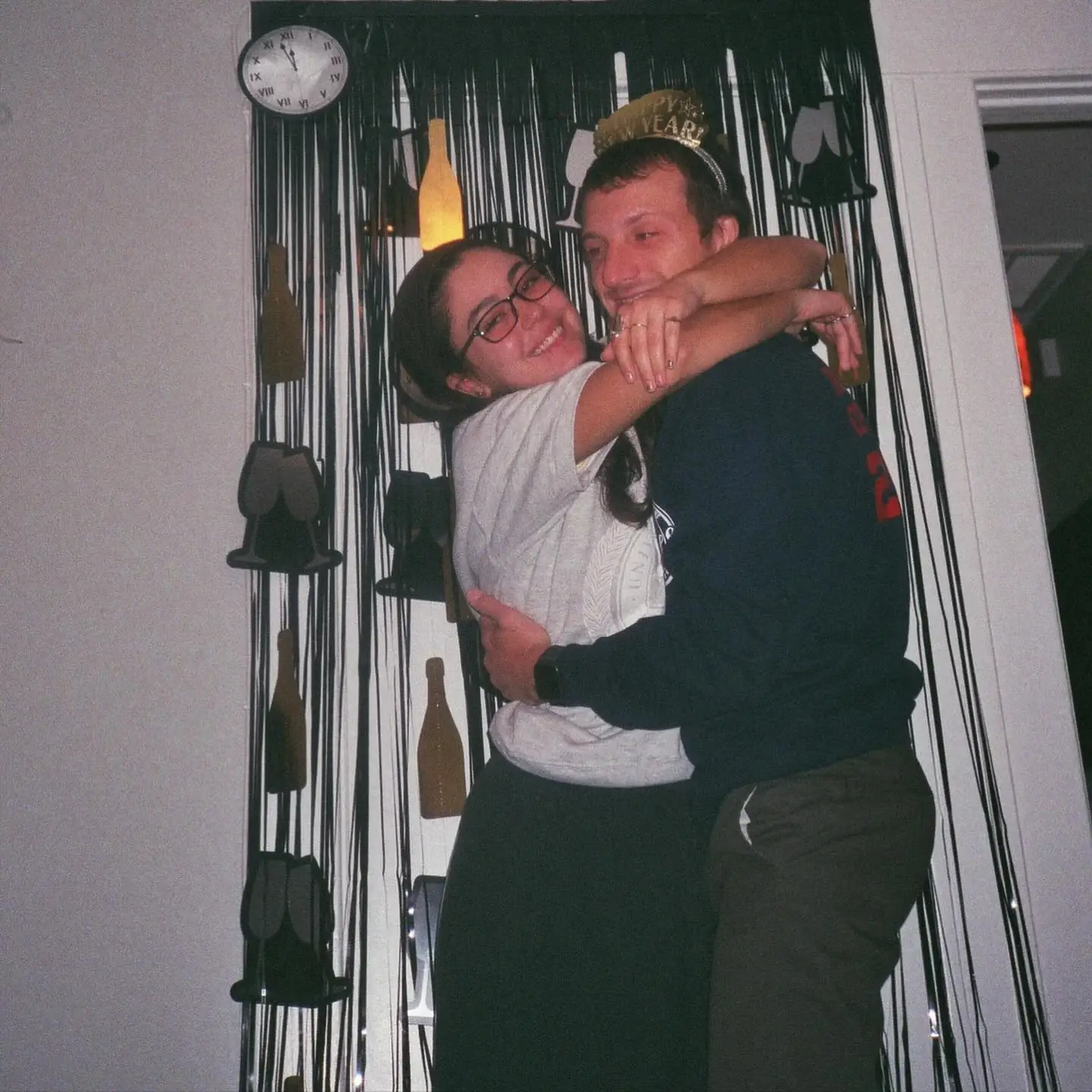 Mika Abdalla wears glasses and a bright smile while wrapping her arms around Jake Short at a New Year