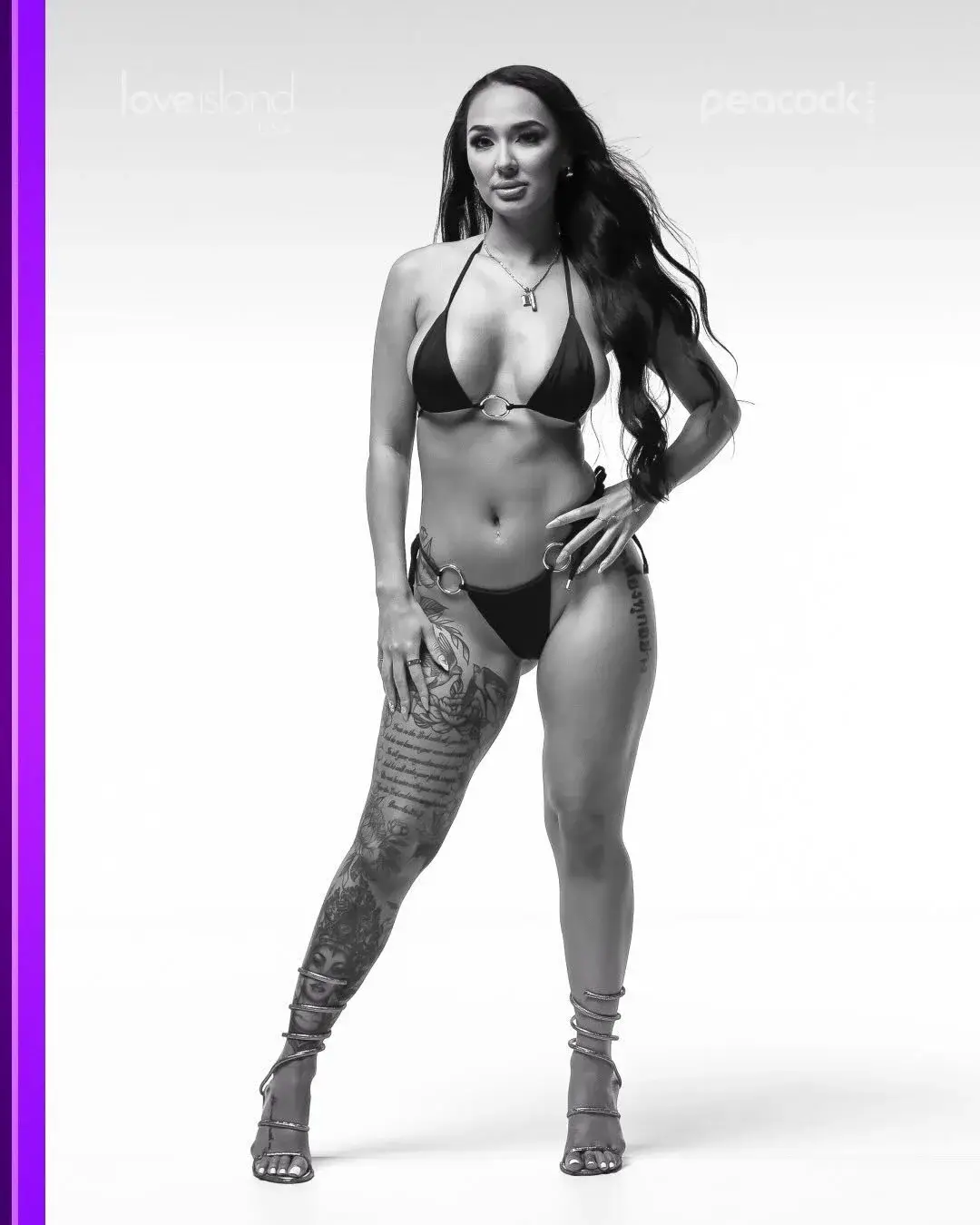 A black-and-white promotional portrait of Vasana Montgomery standing in a string bikini with metal rings and displaying prominent leg tattoos.