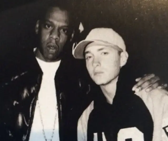 A vintage black-and-white photograph of rap icons Jay-Z and Eminem standing side by side while looking directly at the camera.