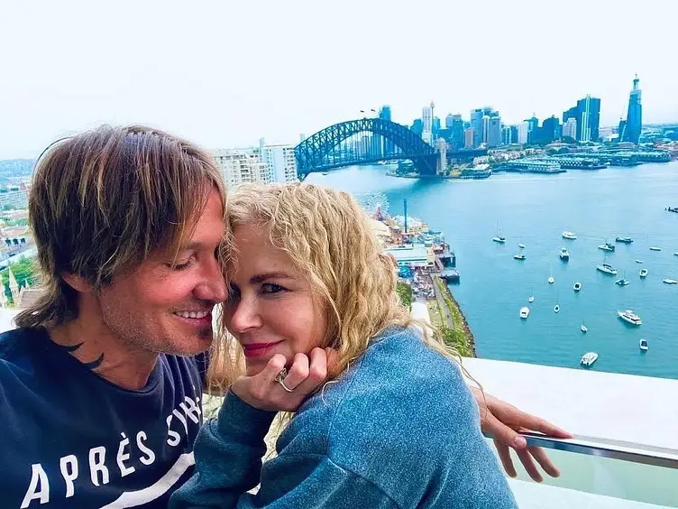 Keith Urban and his ex wife, Nicole Kidman cuddle together affectionately on a high balcony overlooking Sydney Harbour and the Harbour Bridge.