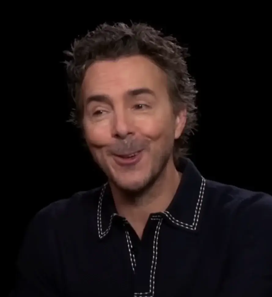 Director Shawn Levy smiles during an interview while wearing a dark polo shirt with white contrast stitching.