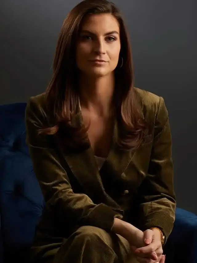 Journalist Kaitlan Collins sits in an armchair wearing an olive green corduroy suit.