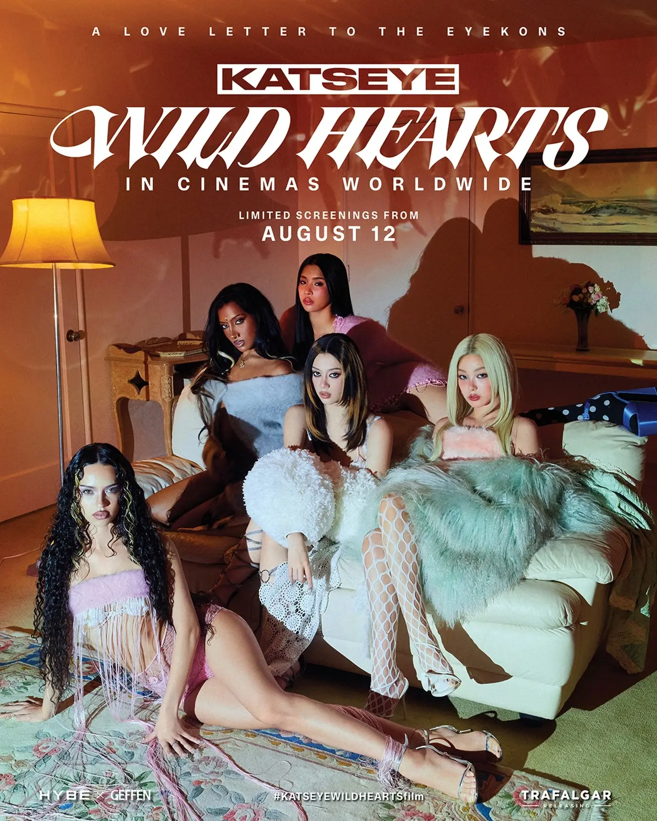 Promotional poster for KATSEYE WILD HEARTS featuring five members posing in stylish outfits inside a warm, vintage-style room.