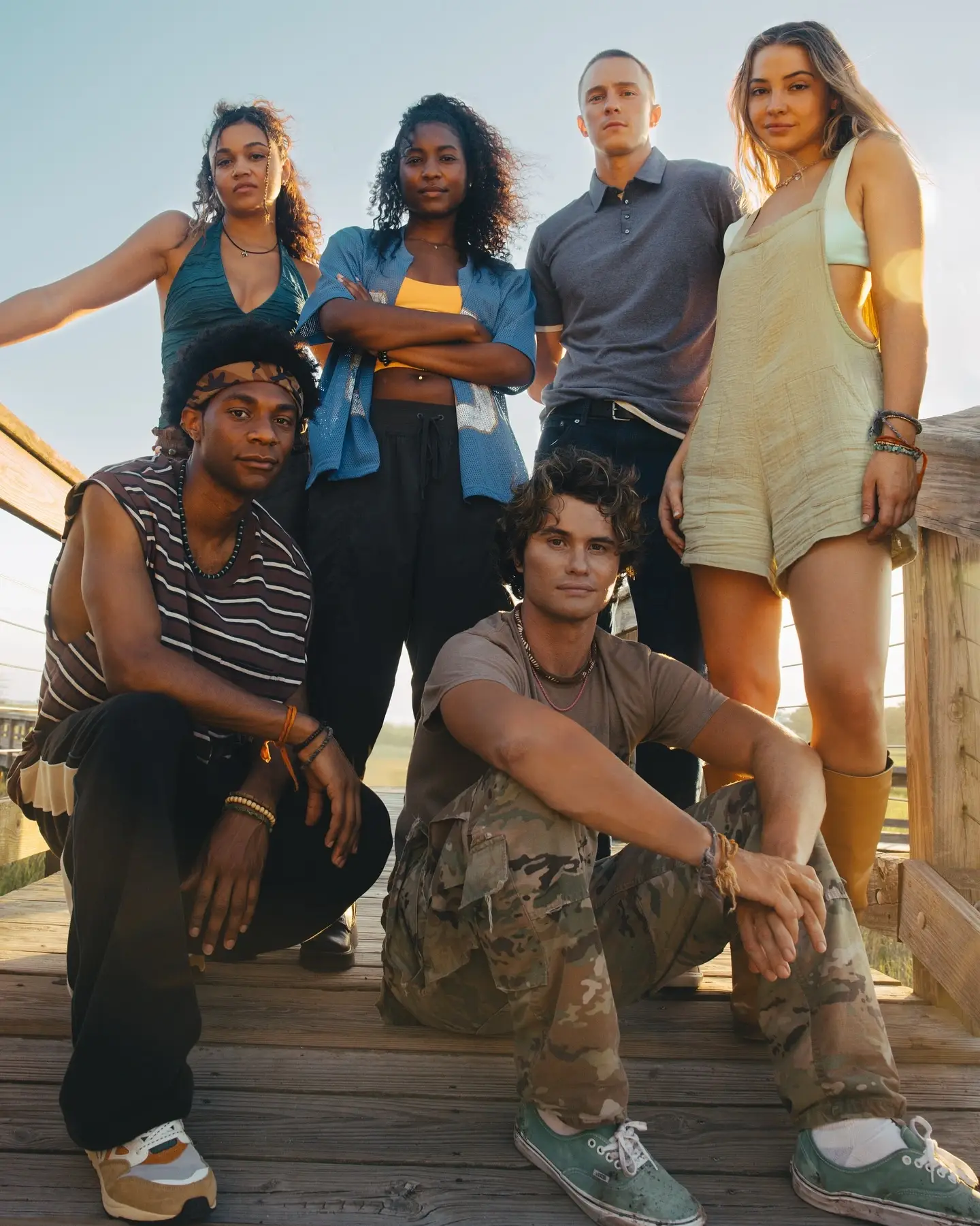 Carlacia Grant posing outdoors on a wooden deck with Outer Banks cast members Madison Bailey, Drew Starkey, Madelyn Cline, Jonathan Daviss, and Chase Stokes.