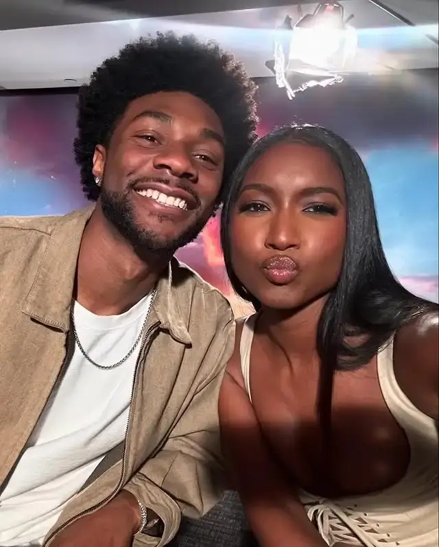 Carlacia Grant posing for a close-up selfie alongside Jonathan Daviss as she makes a playful kiss face and he smiles warmly.