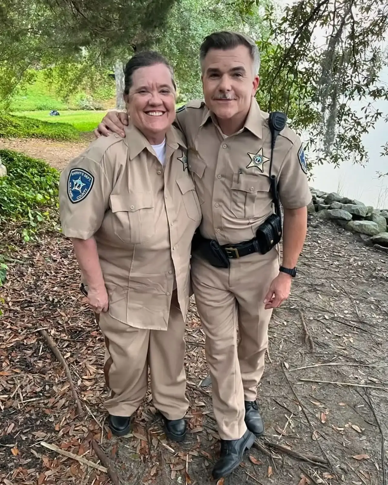Cullen Moss and Brandy Sullivan smiling warmly while posing outdoors together in matching beige Kildare County Sheriff