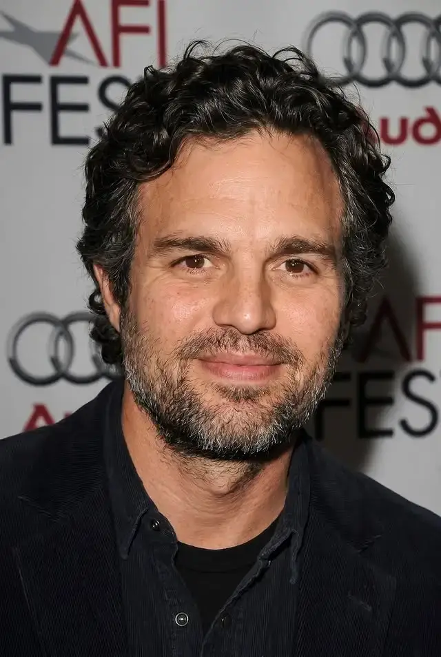 Mark Ruffalo smiling in a dark corduroy jacket at an AFI Fest red carpet event.